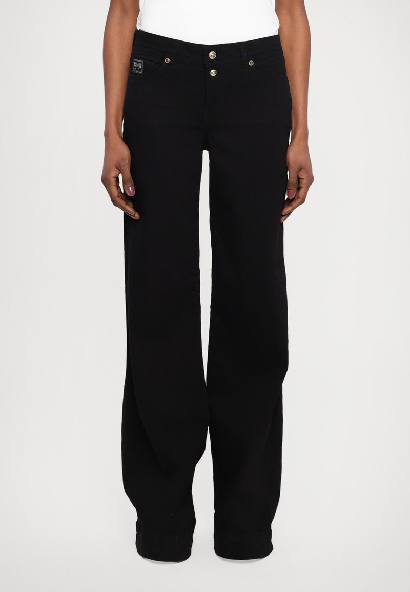 Black wide-leg jeans made of denim, featuring a high waist, two front buttons, and subtle branding on the waistband.