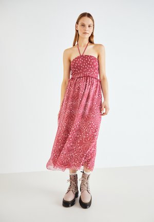 Rochie lungă roz, cu guler halter, cu un corset pliat, material cu modele geometrice și florale, asortată cu cizme groase, cu șireturi.