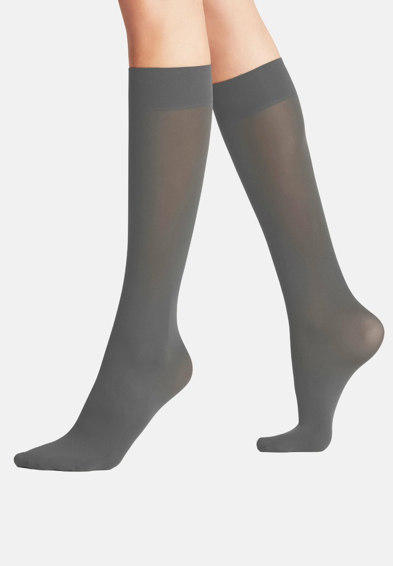 Kniehoge, doorschijnende grijze sokken met een gladde textuur, voorzien van een solide boord en een versterkte teen voor duurzaamheid. Ideaal voor formele of zakelijke kleding.