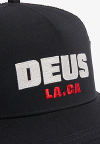 Gorra negra con visera rígida, que presenta un audaz texto blanco "DEUS" y acentos bordados rojos "LA.CA". Hecha de un tejido duradero.