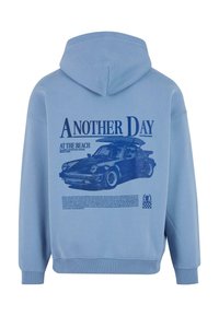 Felpa azzurra chiara con una stampa grafica di un'auto e testo sul retro. Realizzata in tessuto morbido; include un cappuccio e polsini a coste.