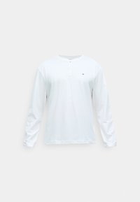 T-shirt blanc à manches longues en coton avec un col rond, doté d'une patte de boutonnage et d'un petit logo sur la poitrine. Design simple, texture lisse.