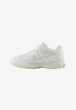 Scarpa da ginnastica bianca con tomaia in mesh e pelle sintetica, suola strutturata, dettagli con logo e particolare verde neon sul tallone.