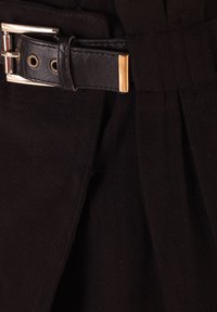 Tela de lana negra con un diseño estructurado, que incluye un cinturón ancho hecho de cuero negro, decorado con una hebilla y ojales de metal en tono dorado.