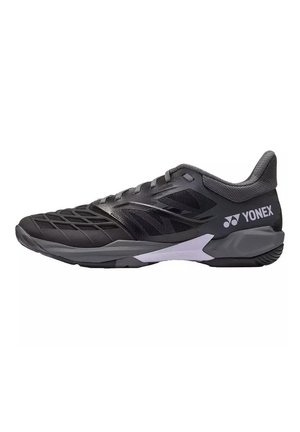 Zapatilla deportiva Yonex negra y gris con parte superior de malla, cuello acolchado y logo de la marca en el lateral, diseñada para deportes de interior.