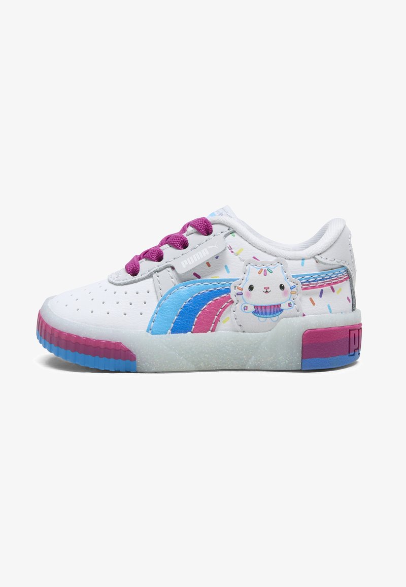 Valkoiset tennarit, joissa on värikkäitä yksityiskohtia, mukaan lukien siniset ja vaaleanpunaiset raidat, violetit nauhat ja cartoon-tyylinen cupcakesuunnittelu sivulla. Teksturoitu pohja.