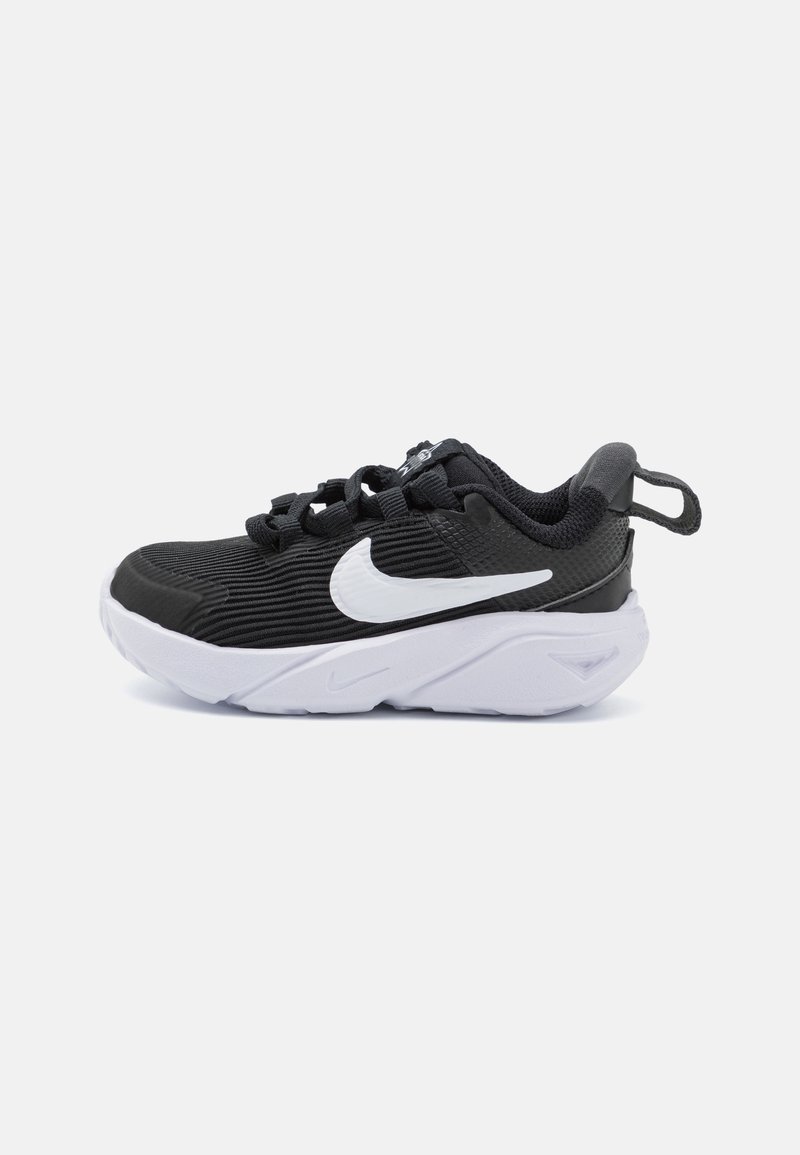 Baskets noires de sport avec une tige texturée, swoosh Nike blanc et semelle en caoutchouc. Dotées d'un système de fermeture par cordon et d'une languette de traction.