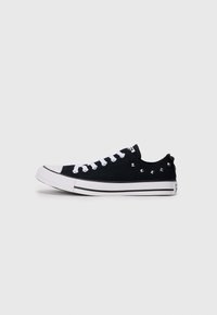 Mustad musta kangaga sportlikud sneakers valgete paelte ja kummist tallaga, külgedel hõbedaste nupukestega ning kahel mustal triigil tallal.