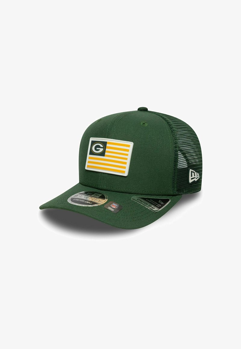 Casquette de baseball verte avec un design avant solide, présentant un patch blanc avec des bandes jaunes et un logo. Dos en maille et fermeture à pression.