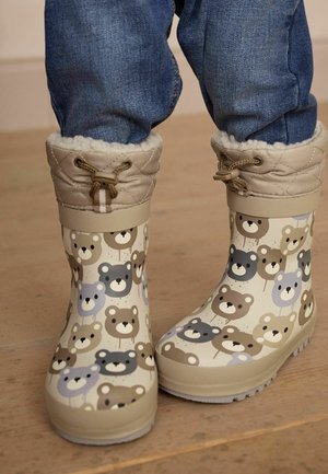 Bottes de pluie imperméables marron et beige avec des imprimés d'ours ; haut matelassé avec doublure en fausse fourrure beige et lacets pour ajustement. Semelle texturée pour une meilleure adhérence.