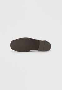 Suela de zapato de cuero marrón con una superficie texturizada y surcos para la tracción. Forma redondeada con un acabado general suave.