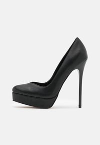 Svart høyhelte sko med en glatt skinntekstur, rund tå, plattformsåle og stiletthæl. Elegante linjer med minimal detaljering.