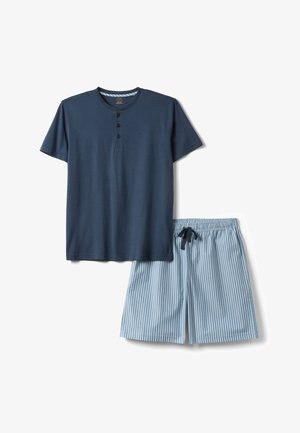 Korte mouwen navy blauwe henley shirt gecombineerd met lichtblauwe en witte verticale gestreepte shorts met een trekkoord in de taille.