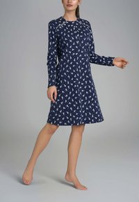 Abito lungo blu navy a maniche lunghe con colletto abbottonato, caratterizzato da un motivo floreale bianco. Tessuto morbido e design fino al ginocchio.