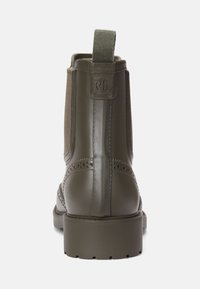 Botins até ao tornozelo em verde-azeitona com exterior em borracha lisa, painéis laterais em têxtil, detalhe perfurado e uma alça de puxar na parte de trás.