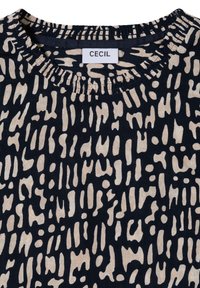 Laivastonsininen puuvillapaita, jossa on kerma-aiheinen abstrakti kuvio, pyöreä, ryhdistetty pääntie ja 