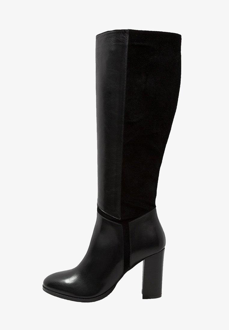 Botas negras hasta la rodilla que presentan una combinación de cuero liso y ante, con tacón cuadrado y un diseño ajustado, adecuadas para diversas prendas.