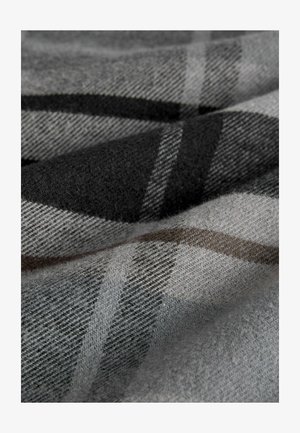 Šedá károvaná textília s jemnou vlnitou štruktúrou. Vzory obsahujú čierne a svetlošedé pruhy, s jemnými hnedými akcentmi.
