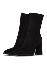 Black ankle boots made of smooth suede. Features a pointed toe and a chunky heel. Simple design with stitching along the sides.