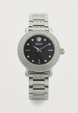 Nerūdijančio plieno laikrodis su juodu apvaliu ciferblatu su raštu, sidabriniais valandų žymekliais ir bezeliu su graikų rakto motyvu. Papuoštas „Versace“ logotipu ir sidabrine apyranke.