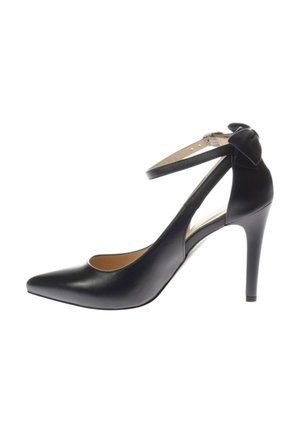 Chaussure à talons hauts en cuir noir avec un bout pointu, une bride à la cheville et un détail en nœud. Fini brillant, design structuré et talon fin.