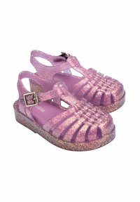 Sandali in gel rosa glitterati con un design a strisce, chiusura con fibbia e suola spessa. Superficie testurizzata con una finitura lucida.