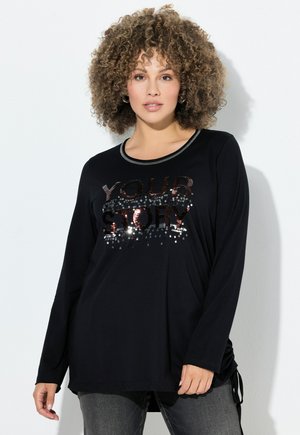 Schwarzes Langarmshirt mit einer "DEINE GESCHICHTE" Pailletten-Grafik. Weiches Material mit einem runden Ausschnitt und seitlichen Bändern für eine verstellbare Passform.