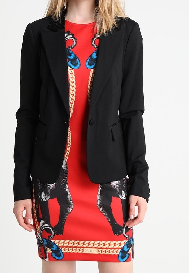 Veste noire ajustée, coupe cintrée, fermeture à un bouton, associée à une robe rouge ornée d'imprimés animaliers et de motifs de chaînes bleues. Texture lisse.