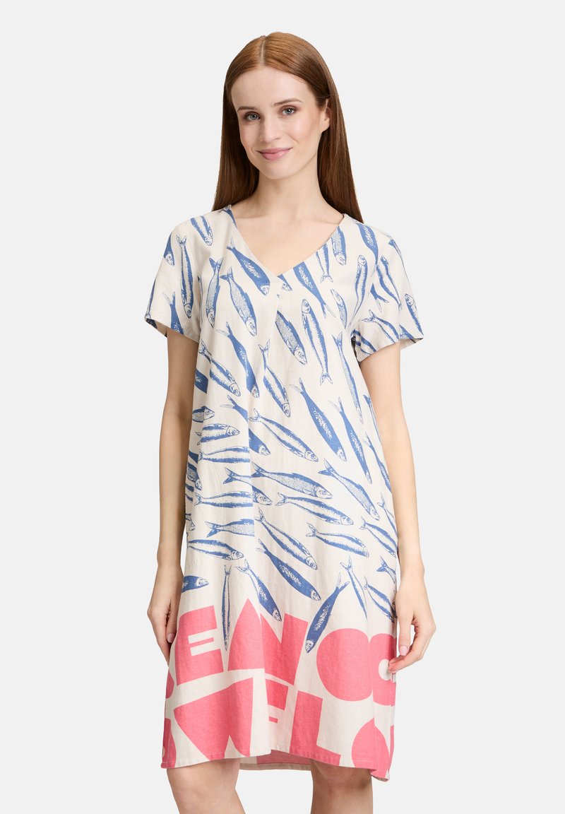 Leinenkleid mit V-Ausschnitt und kurzen Ärmeln, das blaue Fischmuster auf einem beigen Hintergrund und fetten pinken Text am unteren Rand aufweist.