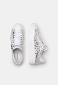 Bílé kožené tenisky se stříbrnými akcenty, texturovaná tkanina, šněrování, polstrovaný límec a dekorativní zipový detail na straně.