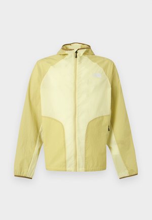 Hellgelbe, kapuzenlose, leichte Jacke mit Frontreißverschluss und The North Face-Logo auf der Brust, entworfen für den Outdoor-Einsatz.