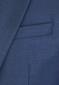 Zbliżenie ciemnogranatowej marynarki garniturowej, pokazującej klapę i wszytą kieszeń na teksturowanej tkaninie.