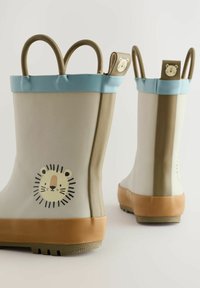Bottes de pluie pour enfants en caoutchouc, beige clair avec un contour bleu, design de visage de lion sur le côté, et deux poignées en haut. Semelle texturée pour l'adhérence.