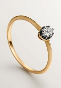 Anillo de oro con banda lisa y un diamante redondo de corte brillante engastado en una configuración de textura de metal negro.