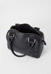 Black leather handbag with a textured finish, gold hardware, dual handles, and a zip closure; features a logo print and inner compartments.