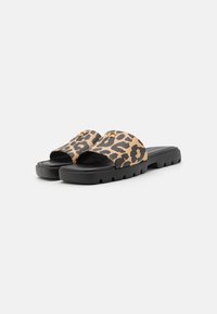 Leopard print slide sandals with a black rubber sole and thick midsole, featuring a wide strap and a smooth texture. Gold accent detail included.