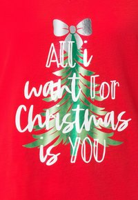 Czerwona bawełniana koszulka z grafiką zielonej choinki oraz białym i srebrnym napisem "All I want for Christmas is You" (Wszystko, czego chcę na Boże Narodzenie, to Ty).