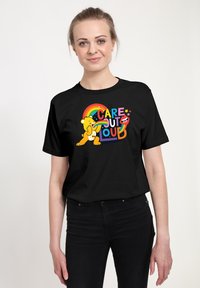 Černé bavln�ěné tričko s barevným potiskem, na kterém je medvěd, duha a text "PEČUJ NIKDY NEHLAĎ." Krátké rukávy a kulatý výstřih.