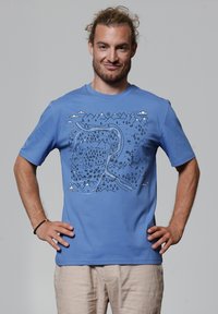 Blauwe katoenen t-shirt met een grafisch ontwerp van bergen, bomen en wolken in het zwart, met een relaxte pasvorm en korte mouwen.