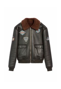 Czarna skórzana kurtka bombowiec z brązowym kołnierzem z sztucznego futra, dwoma przednimi kieszeniami oraz różnymi haftowanymi naszywkami w kolorach niebieskim, czerwonym i kremowym.