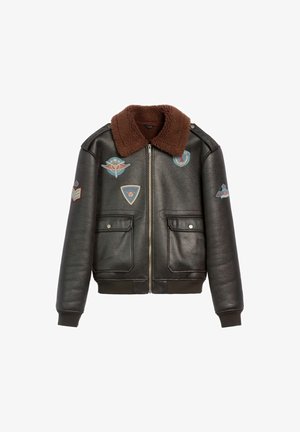 Czarna skórzana kurtka bombowiec z brązowym kołnierzem z sztucznego futra, dwoma przednimi kieszeniami oraz różnymi haftowanymi naszywkami w kolorach niebieskim, czerwonym i kremowym.