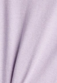 Tissu lavande doux avec une texture tricotée lisse et de subtiles plis créant de douces ombres.