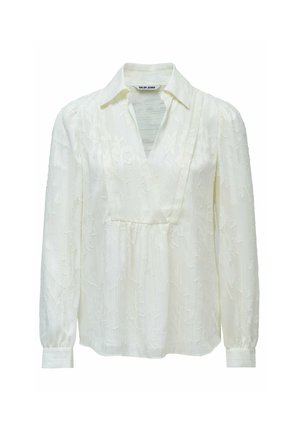 Blusa blanca de manga larga con escote en V, que presenta patrones florales y una sutil textura. Diseñada con un cuello con solapas y puños fruncidos.