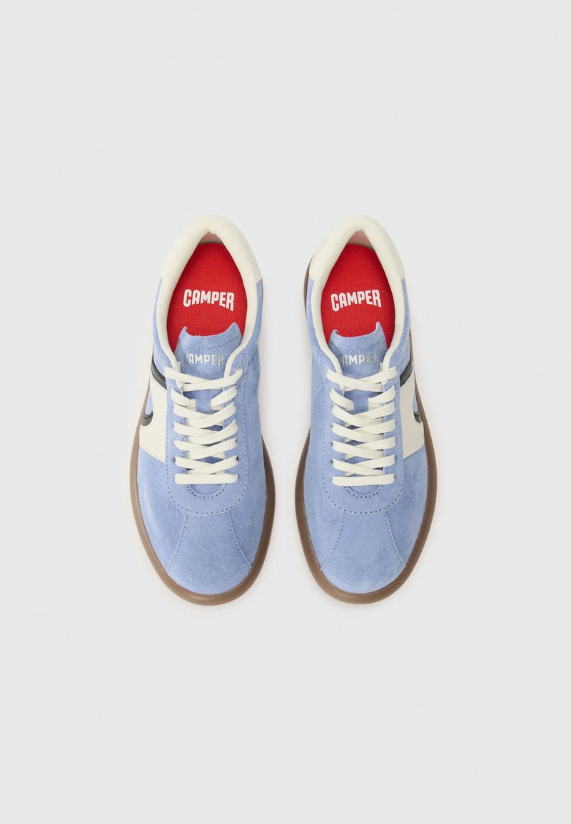 Zapatillas de ante azul claro con un panel lateral blanco y suela de goma marrón. Cordones crema y plantilla roja con la marca "CAMPER".