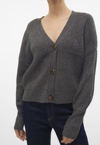 Harmaa neulottu neuletakki, jossa on syvä V-kaula-aukko, pitkät hihat ja kolme ruskeaa nappia, teksturoidulla kankaalla ja lyhyellä istuvuudella.