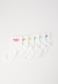 Bijele pamučne čarape s rebrastim rubovima, s obojenim logotipom na svakoj: ružičasta, žuta, zelena, plava i svijetlo plava, raspoređene u redu.