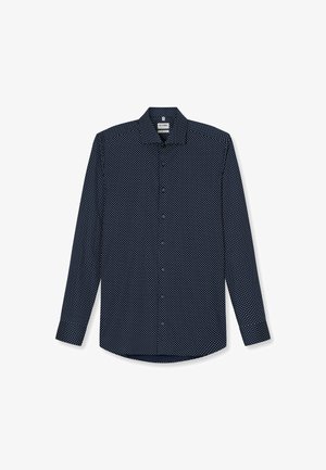 Chemise à manches longues bleu marine avec un motif à pois blancs, un col boutonné et un ourlet arrondi. Fabriquée en tissu léger.