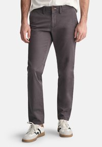 Grijze katoenen chino's met een rechte pijp, voorzien van zijzakken, een rits-vly, en een taillebandlus met een bruin knoopaccent.