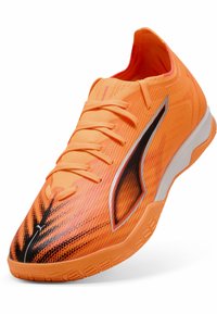 Scarpa sportiva di colore arancione brillante con superiore texturizzato, dettagli neri e argentati e lacci piatti. Presenta una suola curva per maggiore agilità.