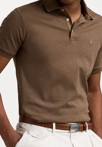 Polo castanho feito de tecido leve com gola, dois botões e um pequeno logótipo bordado no peito.